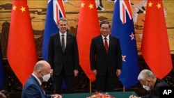 Perdana Menteri China Li Qiang, kanan belakang, dan Perdana Menteri Selandia Baru Chris Hipkins, kiri belakang, menghadiri upacara penandatanganan di Aula Besar Rakyat di Beijing Rabu, 28 Juni 2023. (Jade Gao/Pool via AP)