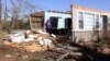 Yvonne Hayes mira la pila de escombros, el sábado 25 de marzo de 2023, después de que una tormenta derribó el techo y la pared norte de su casa la noche anterior en Amory, Misisipi. (AP Photo/Jim Lytle)