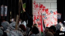 Grupa demonstranata je umočila ruke u crvenu farbu koja simbolizuje krv i ostavila otiske na ogradi oko Biele kuće. (Foto: Stefani Reynolds / AFP)