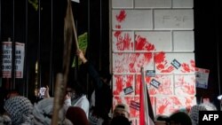Grupa demonstranata je umočila ruke u crvenu farbu koja simbolizuje krv i ostavila otiske na ogradi oko bele kuće (Foto: Stefani Reynolds / AFP)