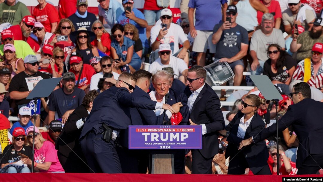 El candidato presidencial republicano y expresidente de EEUU, Donald Trump, es asistido por personal del Servicio Secreto después de que se escucharon disparos durante un mitin de campaña en el Butler Farm Show en Butler, Pensilvania, el 13 de julio de 2024.