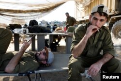 Israeli soldiers rest outside the border with northern Gaza, in Southern Israel, Nov. 17, 2023