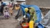 FILE - Congolese woman and children reside in a camp for internally displaced people in Kanyaruchinya near Goma, North Kivu province of the Democratic Republic of Congo, Feb. 16, 2023.