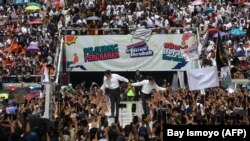 Calon presiden dan wakil presiden, Anies Baswedan (kiri) dan Muhaimin Iskandar, menyapa pendukungnya saat kampanye di Jakarta International Stadium, Jakarta pada 10 Februari 2024. (Foto: AFP/Bay Ismoyo)