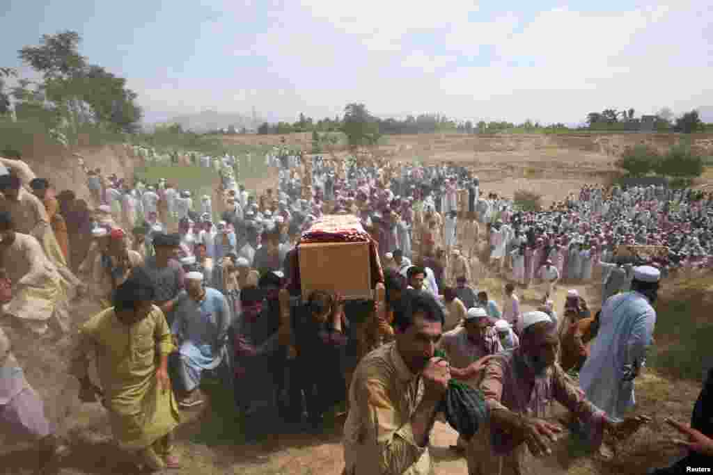 Луѓето ги носат ковчезите на жртвите, кои беа убиени во експлозија, за време на погребот во областа Бајаур во провинцијата Хајбер Пахтунхва, Пакистан.