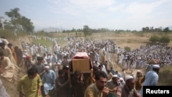 FILE - People carry the coffins of those who were killed in a blast, during a funeral in the Bajaur district of Khyber Pakhtunkhwa province, Pakistan, July 31, 2023.