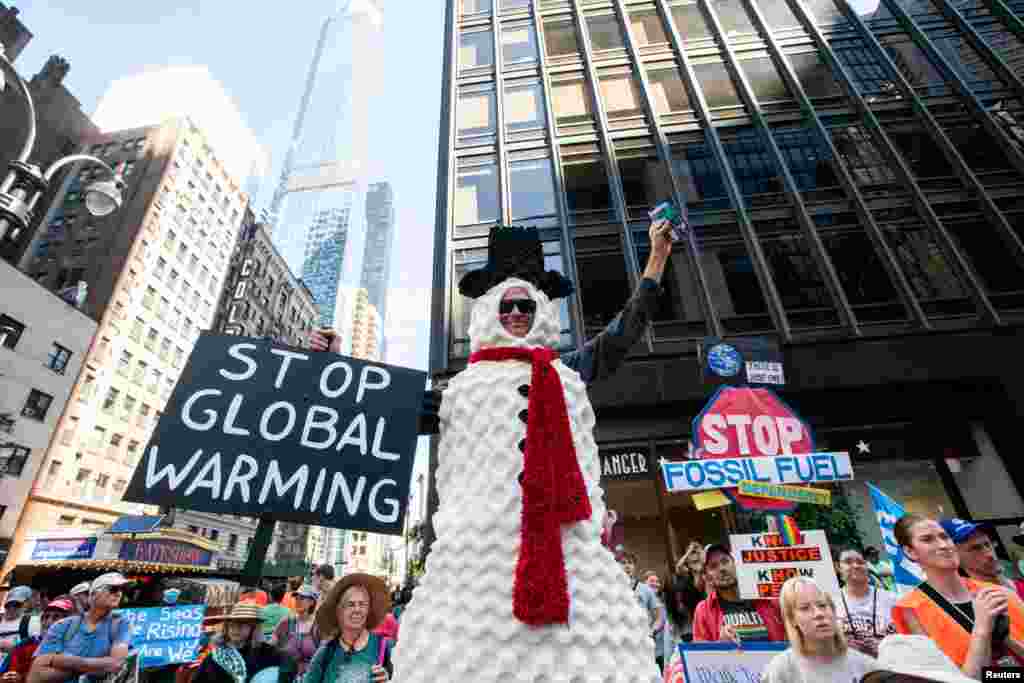 Activists gather around Times Square in New York City as they mark the start of Climate Week in New York during a demonstration calling for the U.S. government to take action on climate change and reject the use of fossil fuels.