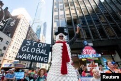 Activists gather around Times Square as they mark the start of Climate Week in New York during a demonstration calling for the U.S. government to take action on climate change and reject the use of fossil fuels in New York City, Sept. 17, 2023.