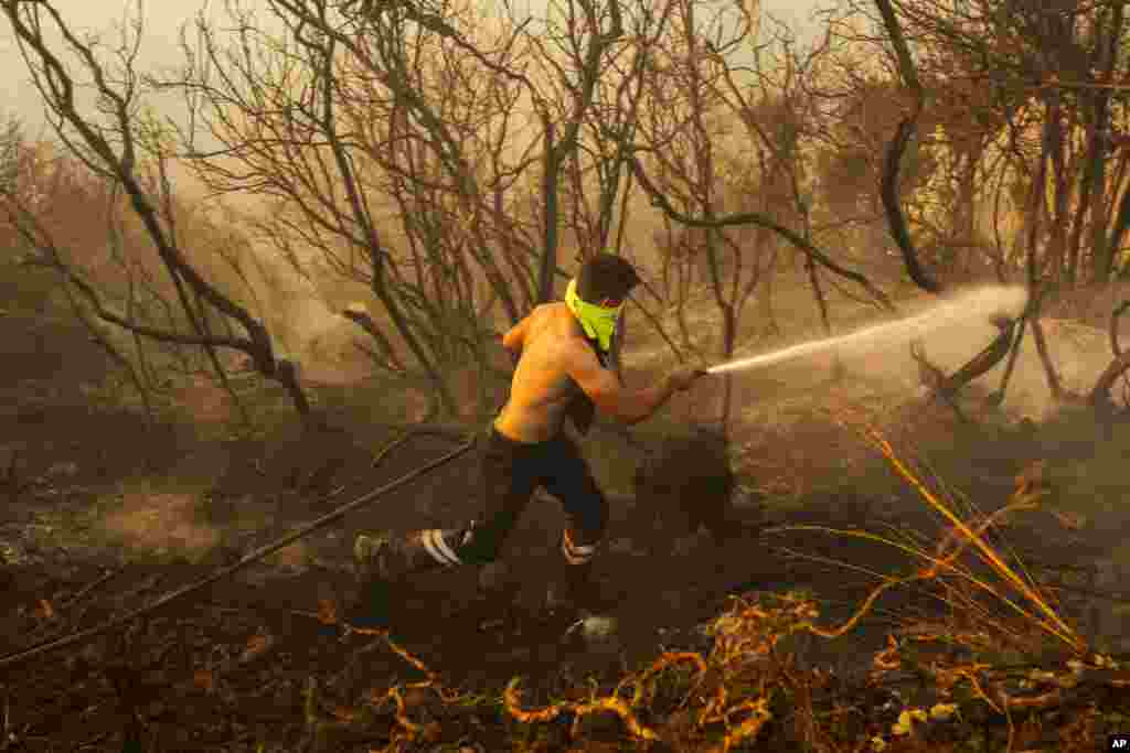 A firefighter works to extinguish a wildfire at a forest in Beykoz, on the outskirts of Istanbul, Turkey.