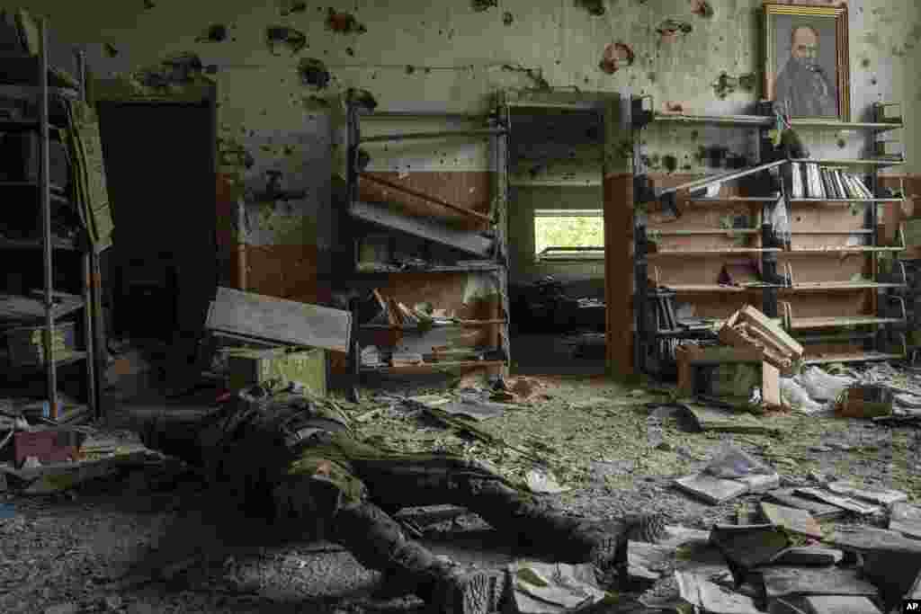 El cadáver de un soldado ruso, en el interior de un edificio en la localidad de Blahodatne, Ucrania, el 17 de junio de 2023.&nbsp; (AP Foto/Evgeniy Maloletka).