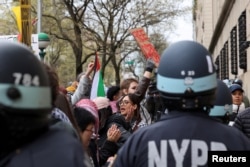 Agentes del orden hacen guardia mientras manifestantes protestan en solidaridad con los organizadores pro-palestinos en el campus de la Universidad de Columbia, en medio del conflicto entre Israel y Hamás, en la ciudad de Nueva York, el 18 de abril de 2024. REUTERS/Caitlin Ochs
