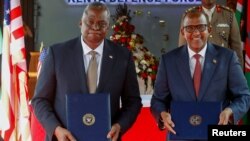 U.S. Secretary of Defense Lloyd Austin, left, and Kenya's Cabinet Secretary for Defense Aden Duale hold copies of a Defense Cooperation Agreement in Nairobi, Kenya, Sept. 25, 2023. 