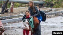 Mulher e filha palestinianas deixam norte de Gaza, 27 novembro 2023.