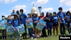 FILE - Demonstrators lock arms during a rally with migrant families and immigration advocates calling for a pathway towards citizenship, on Capitol Hill in Washington, Sept. 20, 2021. 