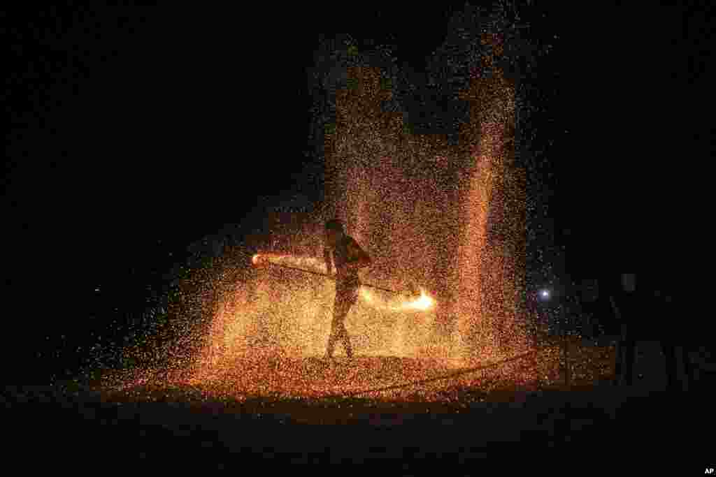 A fire dancer performs during a show for tourists on Batu Ferringhi Beach on Penang Island, Malaysia.