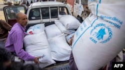 (FILE) Displaced Yemenis receive humanitarian aid provided by the World Food Programme (WFP) in the city of Taiz on September 11, 2023. 