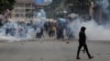 A police officer walks after using tear gas to disperse protesters during a demonstration over police killings of people protesting against Kenya's proposed finance bill 2024/2025, in Nairobi, June 27, 2024. 