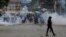 A police officer walks after using tear gas to disperse protesters during a demonstration over police killings of people protesting against Kenya's proposed finance bill 2024/2025, in Nairobi, June 27, 2024. 