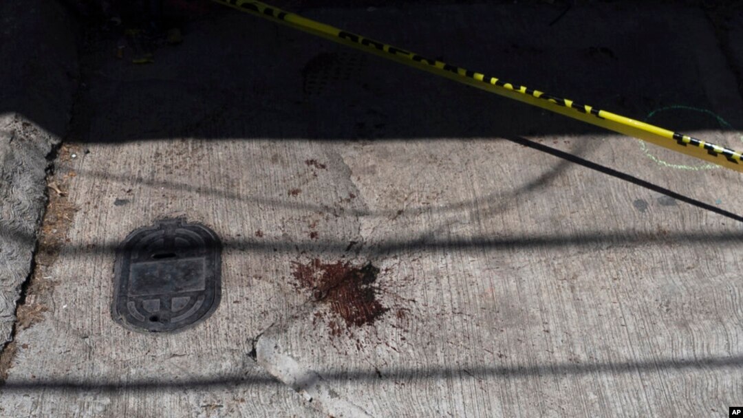 La sangre mancha la acera cerca de la entrada de la casa donde el periodista Armando Linares fue asesinado a tiros, en Zitácuaro, estado de Michoacán, México, el 16 de marzo de 2022.