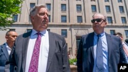 FILE - Former President Donald Trump's lawyers, James Trusty, left, and John Rowley, leave the Department of Justice, June 5, 2023, in Washington. The two said June 9 that they had resigned their roles and would no longer be representing him.