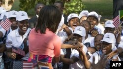 Mke wa Rais wa Marekani Michelle Obama akiwasalimia wasichana jijini Dar es Salaam, Tanzania, Julai 1, 2013. Picha JIM WATSON/AFP.