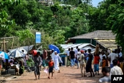 Rohingya refugees gather to buy essentials at a market area in Kutupalong camp a day after cyclone Mocha made landfall, in Ukhia, Bangladesh, May 15, 2023.