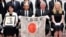USS Lexington Museum executive director Steve Banta, center right, and Toshihiro Mutsuda, center left, the elderly son of Japanese soldier Shigeyoshi Mutsuda, hold Mutsuda's good luck flag after the handover ceremony at Yasukuni shrine in Tokyo, Japan, on July 29, 2023.