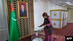 A woman casts her ballot during Turkmenistan's parliamentary elections at a polling station in the town of Annau, some 20 kilometers from the capital Ashgabat, March 26, 2023.