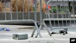 A metal can sits on the ground at the scene where a man lit himself on fire in a park outside Manhattan criminal court in New York, April 19, 2024.