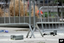 A metal can sits on the ground at the scene where a man lit himself on fire in a park outside Manhattan criminal court in New York, April 19, 2024.