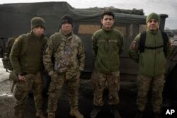 Los veteranos colombianos que se unieron a las fuerzas armadas ucranianas para ayudar a luchar contra Rusia posan para una fotografía cerca de su Humvee en la línea del frente cerca de Lyman, región de Donetsk, Ucrania, el lunes 29 de enero de 2024. (Foto AP/Efrem Lukatsky)