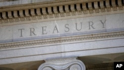 FILE- The U.S. Treasury Department building is shown at dusk in Washington, June 6, 2019.