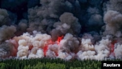 Smoke billows upwards from a planned ignition by firefighters tackling the Donnie Creek Complex wildfire south of Fort Nelson, British Columbia, June 3, 2023. (B.C. Wildfire Service/Handout via Reuters))