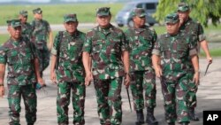 Panglima TNI Laksamana TNI Yudo Margono (tengah), berjalan bersama stafnya di Pangkalan Udara Juanda, Surabaya, Jawa Timur, Selasa, 18 April 2023. (AP/Trisnadi)