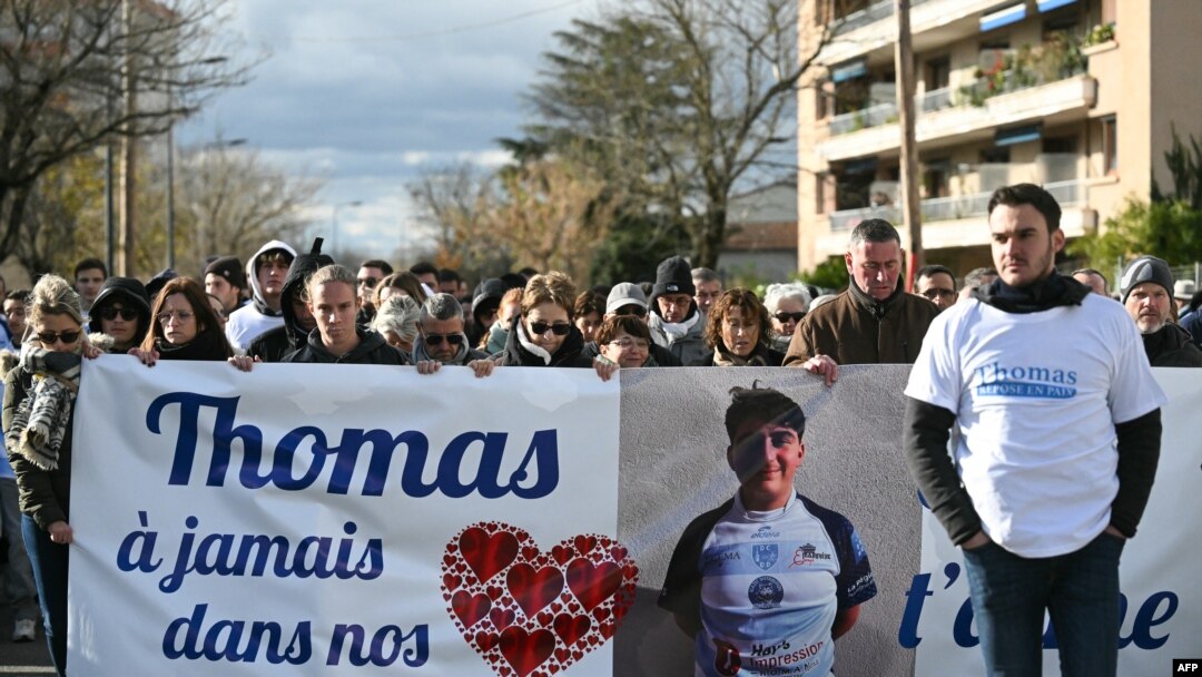 Warga membawa spanduk bertuliskan "Thomas, di hati kami selamanya, kami mencintaimu" di Romans-sur-Isere, Prancis, 22 November 2023, dalam "Marche Blanche" (Pawai Putih) untuk penghormatan kepada Thomas, remaja yang tewas di Crepol, 19 November 2023. (OLIVIER CHASSIGNOLE / AFP)
