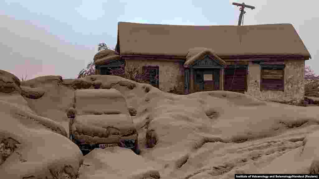 Куќа и автомобил се прекриени со прашина по ерупцијата на вулканот Шивелуч во регионот Камчатка, Русија.