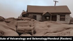 A house and a car are covered in volcanic dust following the eruption of Shiveluch volcano in Kamchatka region, Russia.