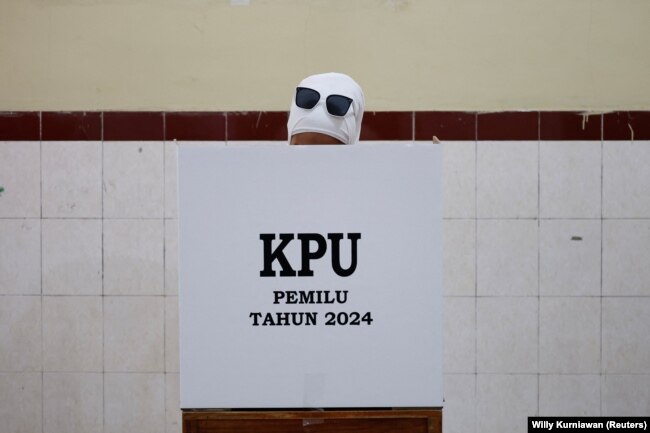 Seorang perempuan memberikan suaranya di TPS saat pemilihan umum, di Surakarta, Jawa Tengah, 14 Februari 2024. (Foto: REUTERS/Willy Kurniawan)