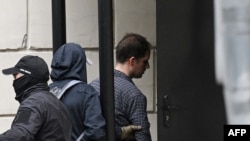 El periodista estadounidense Evan Gershkovich, a la derecha, es escoltado fuera del Tribunal Lefortovsky en Moscú, Rusia, el 24 de agosto de 2023.