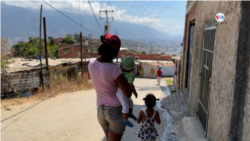 Una mujer lleva a sus hijos a una consulta médica gratuita para evaluar sus pesos y tallas, en Caracas, Venezuela. [Foto: Nicole Kolster]