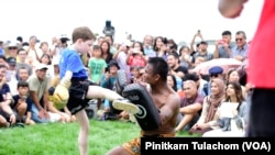 A boy performs a Muay Thai kick with Thailand's champion Sombat Banchamek, or Buakaw, during the Sawasdee DC Thai Festival 2023.