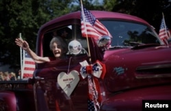Marion Wittenmeyer (98 tahun), melambaikan tangannya dari dalam truk pickup antik melalui Barnstable Village di Cape Cod, saat berlangsungnya parade tahunan dalam rangka merayakan Hari Kemerdekaan AS di Barnstable, Massachusetts, 4 Juli 2024. (REUTERS/Mike Segar)
