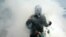 A man wears plastic bottles to spread awareness about mosquito-borne diseases while municipal workers fumigate a locality in Chennai.