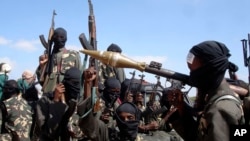 FILE - Armed al-Shabab fighters ride on pickup trucks just outside the Somali capital of Mogadishu, Dec. 8, 2008. 