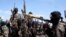 FILE - Armed al-Shabab fighters ride on pickup trucks just outside the Somali capital of Mogadishu, Dec. 8, 2008. 