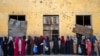 FILE - Afghan women wait to receive food rations distributed by a humanitarian aid group, in Kabul, Afghanistan, May 28, 2023.