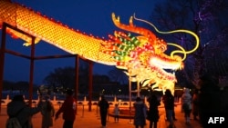 Un dragón gigante atra a los visitantes de un parque de Beijing, China, en la víspera del Año Nuevo Lunar del Dragón. 