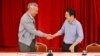Perdana Menteri Singapura Lee Hsien Loong berjabat tangan dengan Menteri Keuangan Lawrence Wong di Singapura, 16 April 2022. (Foto: SPH Media/The Straits Times/Lim Yaohui via REUTERS) 