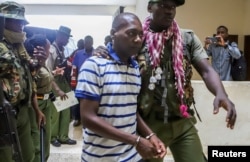 FILE - Paul Mackenzie, a Kenyan cult leader accused of ordering his followers, to starve themselves to death in Shakahola forest, is escorted to the Malindi Law Courts in Malindi, Kilifi, Jan. 17, 2024.