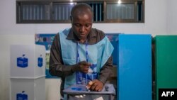 An official from the Independent National Electoral Commission (CENI) seals a ballot box in a polling station at the Reverend Kim School in Kinshasa on December 20, 2023. 